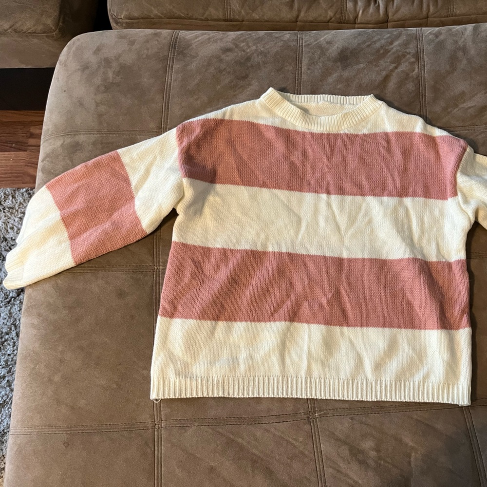 White and pink striped sweater. On the cropped side but, does not show skin.